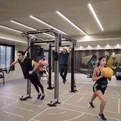 Our functional training area allows for dynamic, multi-faceted workouts. Here, clients use TRX, medicine balls, and pull-up bars simultaneously for a full-body challenge.