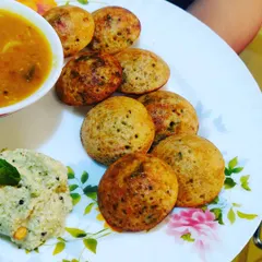 A close-up of our perfectly browned vegetable appe, served with flavourful coconut chutney and sambar.