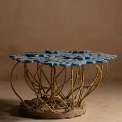The Gul Table is inspired by a bouquet of flowers, frozen in time. We crafted each concrete petal to show the beauty of aging, with cast brass stems rising from a stone-like base. This intricate art furniture piece brings the delicate and complex forms of nature into your living space.