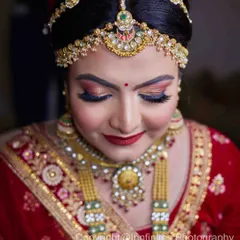 This portrait is all about the details. The focus is on the bride's stunning matha patti and necklace, highlighting the craftsmanship of her bridal jewelry.