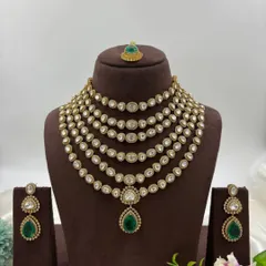 For a truly regal statement, nothing compares to a multi-layered polki and kundan necklace. This 'Satlada' style haar, with its rows of uncut stones and a striking emerald green pendant, is available to rent for a majestic bridal or reception look.