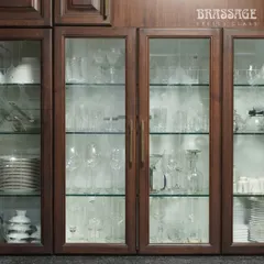 A close-up of our Kiah CL Profile Pulls on glass-fronted display cabinets. The warm brass tones perfectly complement the rich wood grain, creating a harmonious blend of classic charm and modern sophistication.