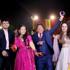 The family dances with joy and energy, celebrating the special milestone together. This shot captures the dynamic and festive spirit of the event.