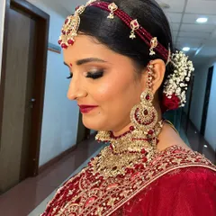 A close-up of the bridal makeup, focusing on the smoky eye and deep red lip color that brings a touch of Bollywood glam to her traditional wedding look.
