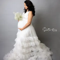 An angelic look for a mom-to-be. This full-length portrait in a white ruffled gown against a clean grey backdrop creates a timeless and elegant maternity photo.