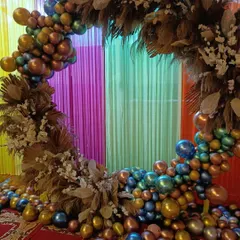 For a fun and festive look, I designed this circular backdrop using a mix of metallic-colored balloons and clusters of dried pampas grass. This style is very popular for modern birthday parties, baby showers, and other lively celebrations.