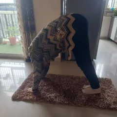Age is no barrier to flexibility. This student is practicing a forward bend during a home visit session, showing great progress in her mobility.