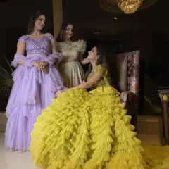 A stunning group shot featuring our multilayered ruffled and frilled gowns in vibrant yellow and soft lavender. This showcases our expertise in creating unique textures and dramatic silhouettes.