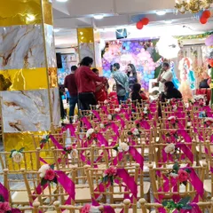 A wide view of the hall prepared for an event, showing the decorated seating area and the stage in the background.