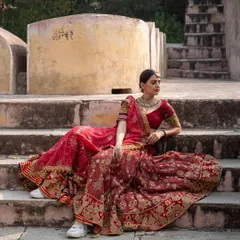 For the bride who wants a truly royal look. This is an incredibly intricate designer bridal lehenga in a classic red, perfect for making a grand entrance on your wedding day.