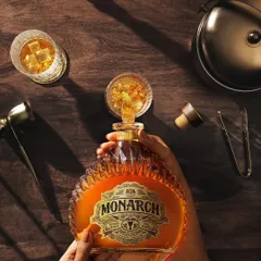 A wider angle of the top-down pour for Monarch Brandy, showing the complete setup with glassware and bar tools. This lifestyle approach helps place the product in a relatable, aspirational context.