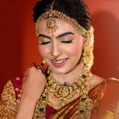 A close-up capturing a bride's blissful expression. This shot provides a detailed look at the muhurtham makeup, with soft pink lips and shimmering eyeshadow.