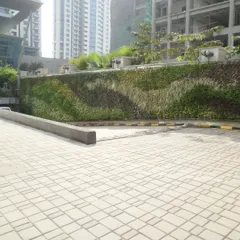 This outdoor facade features a flowing, wave-like pattern created with different plant species. We use a mix of textures and shades of green to design a living mural that changes with the seasons and adds a unique character to the building's exterior.