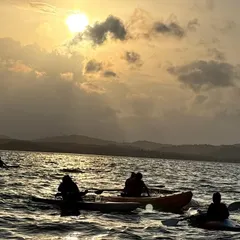 Kayakers pause to watch the sun set over the water. These serene moments are just as much a part of the adventure as the paddling itself.