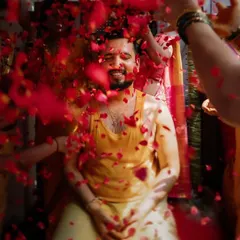 A groom being showered with rose petals during his Haldi. This shot captures the excitement and festive atmosphere of the ceremony.