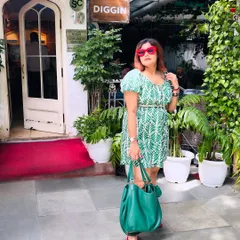 Another angle of this vibrant green and red ensemble. The large green tote bag complements the dress perfectly, while the red accessories add a fiery pop of contrast.