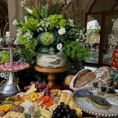 A breathtaking view of the full Champagne & Caviar grazing table, featuring tiers of pastries, cheese boards, fresh bread, olives, and bowls of caviar on ice.
