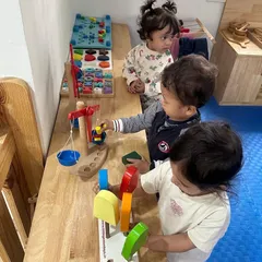 In our Independent Toddler Program, children explore concepts like weight and balance using a wooden scale and colorful blocks.