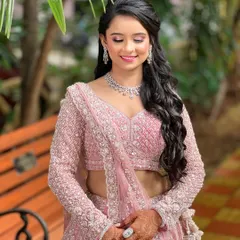 A happy bride-to-be, her smile as radiant as her makeup. The diamond necklace perfectly complements the pink lehenga.