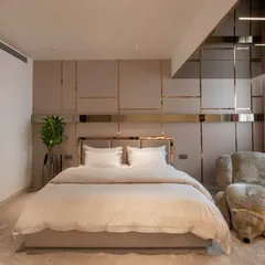 A bedroom should be a personal sanctuary. Here, we used a palette of soft neutrals, refined textures, and custom gold-toned metalwork to create a space that is both luxurious and deeply restful, complete with a unique bear-shaped lounge chair for a touch of playful comfort.