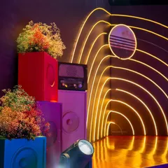 A detail of our orbit-inspired sangeet stage. We stacked colorful speaker boxes with baby's breath and placed a vintage radio next to the neon-lit arch, blending retro and futuristic elements.