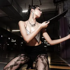 A profile shot from the same series, focusing on the model's silhouette and the texture of the lace tights. The lighting creates a mysterious, dramatic mood.