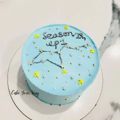 A celestial-themed bento cake for an astrology lover. This mini cake features a hand-piped constellation against a starry blue background, marking the start of "Season 28, ep 1."
