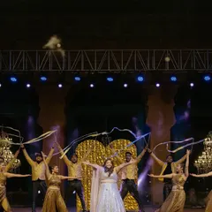 We use props like these flowing ribbons to add movement and color to the stage. This performance was choreographed to create beautiful, sweeping visuals that complement the dancers' movements and the golden decor.
