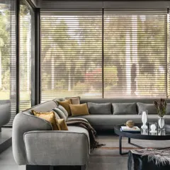 Inside the pool house, comfort is key. I selected this large, curved sectional sofa to create an intimate lounge area that still feels open to the surrounding views. The neutral grey fabric is complemented by warm mustard pillows, adding a pop of color that echoes the natural light.