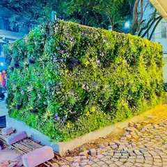 We covered this entire outdoor structure in a mix of colorful artificial foliage. This project, located in a public space, shows the durability and scale of our installations for high-traffic exterior environments.