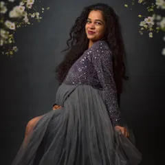 A fine-art maternity portrait. Here, we framed her with delicate floral elements against a dark, textured backdrop to create a feeling of romance and elegance.
