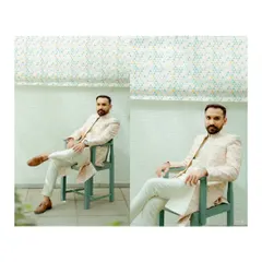 A modern and stylish portrait of the groom, seated and looking sharp in his wedding attire. The clean background and confident pose make for a great shot.