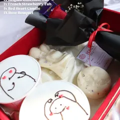 The "Decadent Love" hamper in a red box, featuring two dessert tubs, candles, and a rose bouquet for a classic romantic gesture.