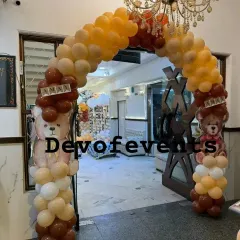 Welcome your guests in style with a themed entrance. This teddy bear balloon arch in shades of brown, beige, and orange creates an inviting entryway for a first birthday party.