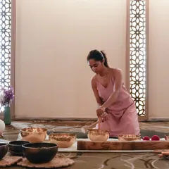 Preparing the sound bowls for a session at a corporate retreat. The serene setting of a hotel or resort enhances the restorative effects of the sound bath for employees.
