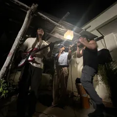 A raw, candid shot from a late-night jam session. This is beatboxing in its natural element, just a few musicians, a mic, and a good vibe under a single light.