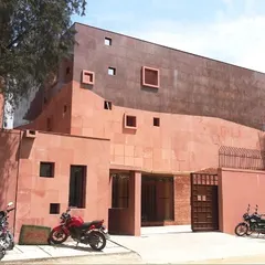 The main facade of the Karigar Centre for Titan Jewellery in Hosur. This project showcases our commitment to using honest, contextual materials. The entire facade is clad in red sandstone, with asymmetrically placed windows that create a unique and sculptural presence, designed to inspire the artisans working within.
