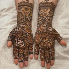 A complete view of a heavy bridal design, extending up the forearms. The symmetry and density of the pattern are key to this traditional bridal style.