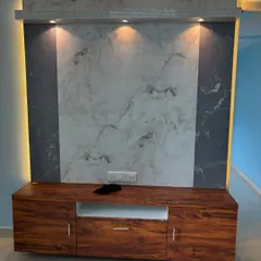 This is a closer look at a floating TV unit we installed. The combination of a rich wood-grain cabinet for storage and a dual-tone marble-effect back panel creates a modern and luxurious feel. The integrated lighting adds depth and ambiance to the living room.