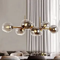 This chandelier features eight smoked silver glass globes on an antique brass frame. It is a contemporary fixture that adds a touch of sophistication and moodiness to a living or dining space.