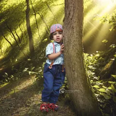 A playful moment in the woods, with sunbeams streaming through the trees. This image captures the sense of adventure and wonder that defines childhood.