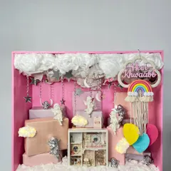 Welcoming a little angel is a magical moment, and this baby announcement hamper was designed to feel like a dream. Set in a custom pink shadow box, it features fluffy clouds, silver cherubs, and a personalized keepsake frame to celebrate new beginnings.