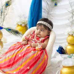 A thoughtful little Radha sitting on her throne. The details, from the pearl headband to the floral bracelets, make this Janmashtami setup so special.