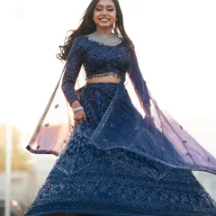 Capturing the pure joy of a reception look. My beautiful bride, Dr. Akshara, is absolutely radiant in this twirling shot, showcasing her sparkling navy blue lehenga. The glam makeup and flowing hair were designed to be perfect for a night of celebration.