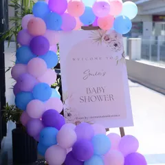 A simple and elegant welcome sign for Sonia's baby shower, framed by a beautiful pastel balloon garland.