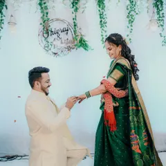 The big question! A classic proposal moment during an engagement ceremony, with the groom on one knee, surrounded by falling rose petals.
