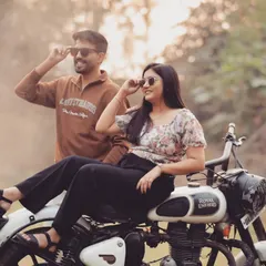 A cool and edgy pre-wedding shot featuring a Royal Enfield bike. This kind of prop adds a lot of personality and makes for a really memorable and stylish couple portrait.