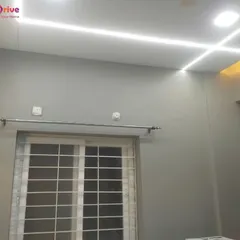 A minimalist false ceiling design featuring clean, intersecting LED strip lights. This creates a sleek and ultra-modern look, providing even, diffused light across the entire room.