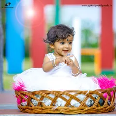 We use simple props like this wicker basket to add texture and interest to our baby portraits without distracting from the subject. This little girl's curious expression is the true highlight of the photo.