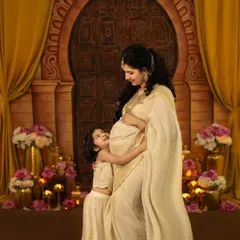 A truly magical moment between a mother and her daughter, eagerly awaiting the new arrival. This maternity session features an elegant, traditional theme with a golden backdrop, rich fabrics, and soft lighting to capture that beautiful pregnancy glow.